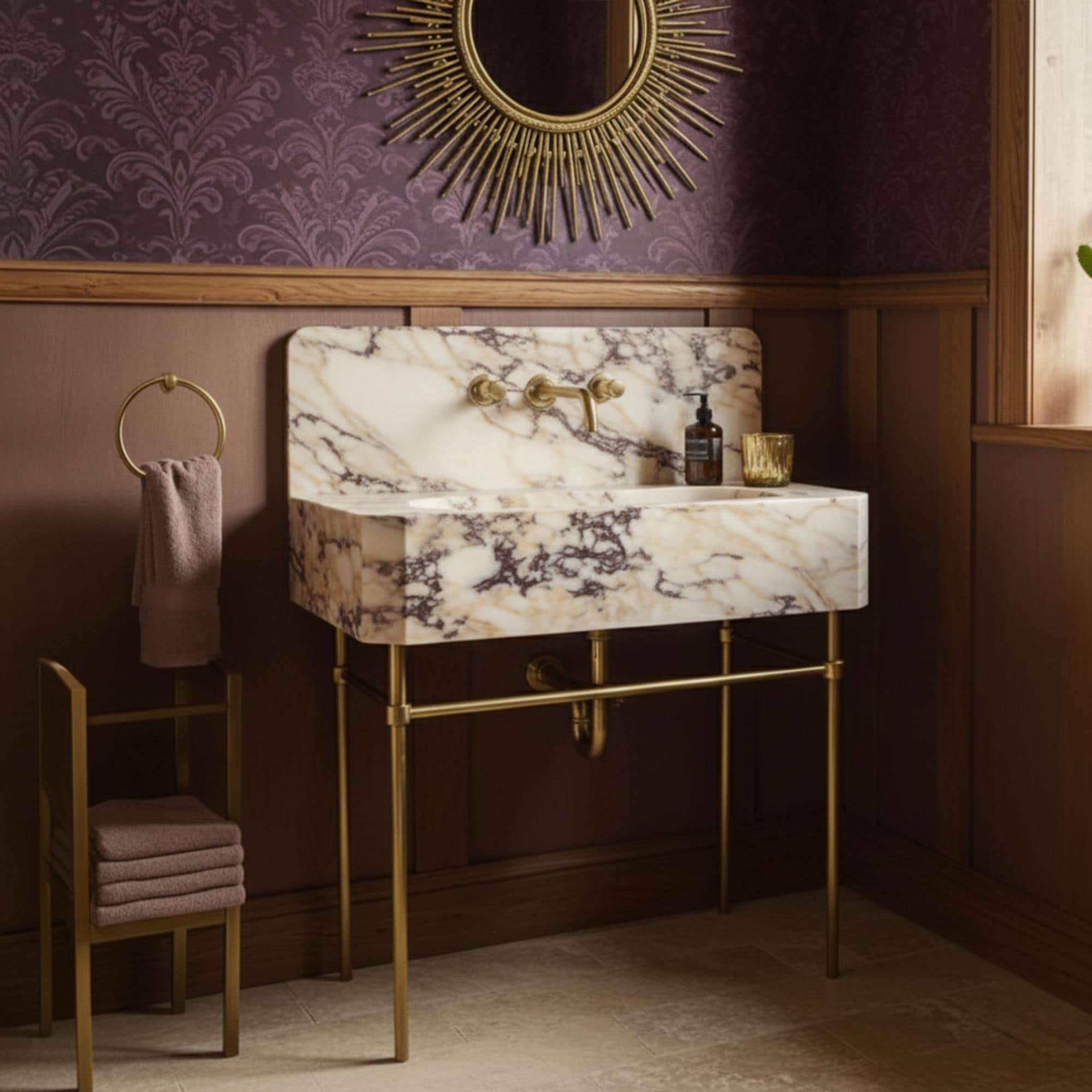 Floating vanity sink in Calacatta Amber Viola marble with bold veining and polished brass legs
