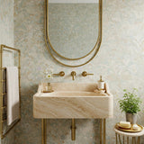 Wall-mounted floating sink crafted from beige travertine marble with rounded edges and brass stand