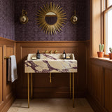 Floating vanity sink made of Calacatta Amber Viola marble with bold veining, paired with a brass stand and wall-mounted faucet