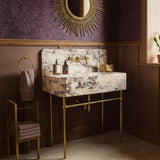 Wall-mounted Calacatta Amber Viola marble sink with integrated backsplash and elegant brass console base