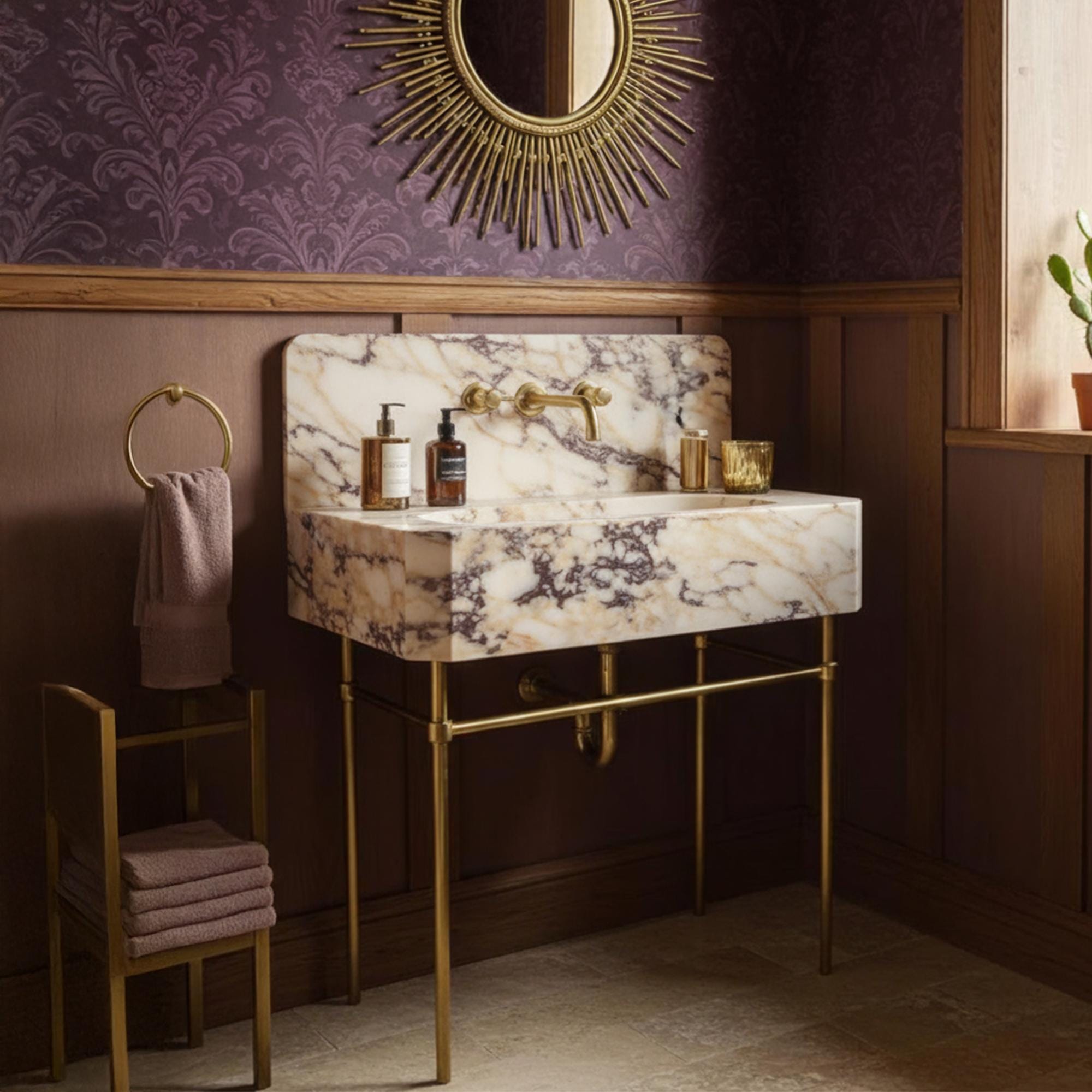 Wall-mounted Calacatta Amber Viola marble sink with integrated backsplash and elegant brass console base