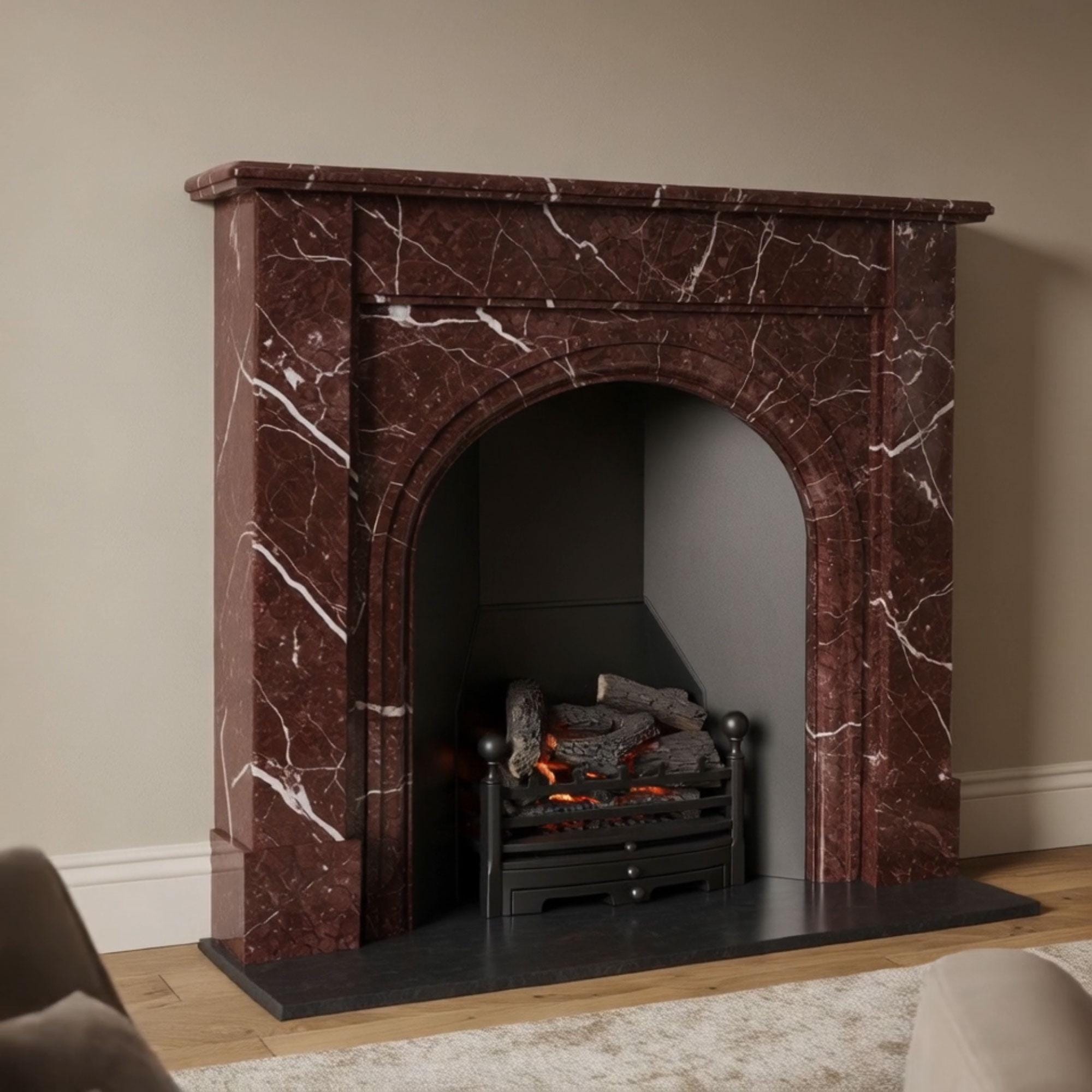 Luxurious custom fireplace mantel made from Rosso Levanto marble with a deep red tone and arched opening