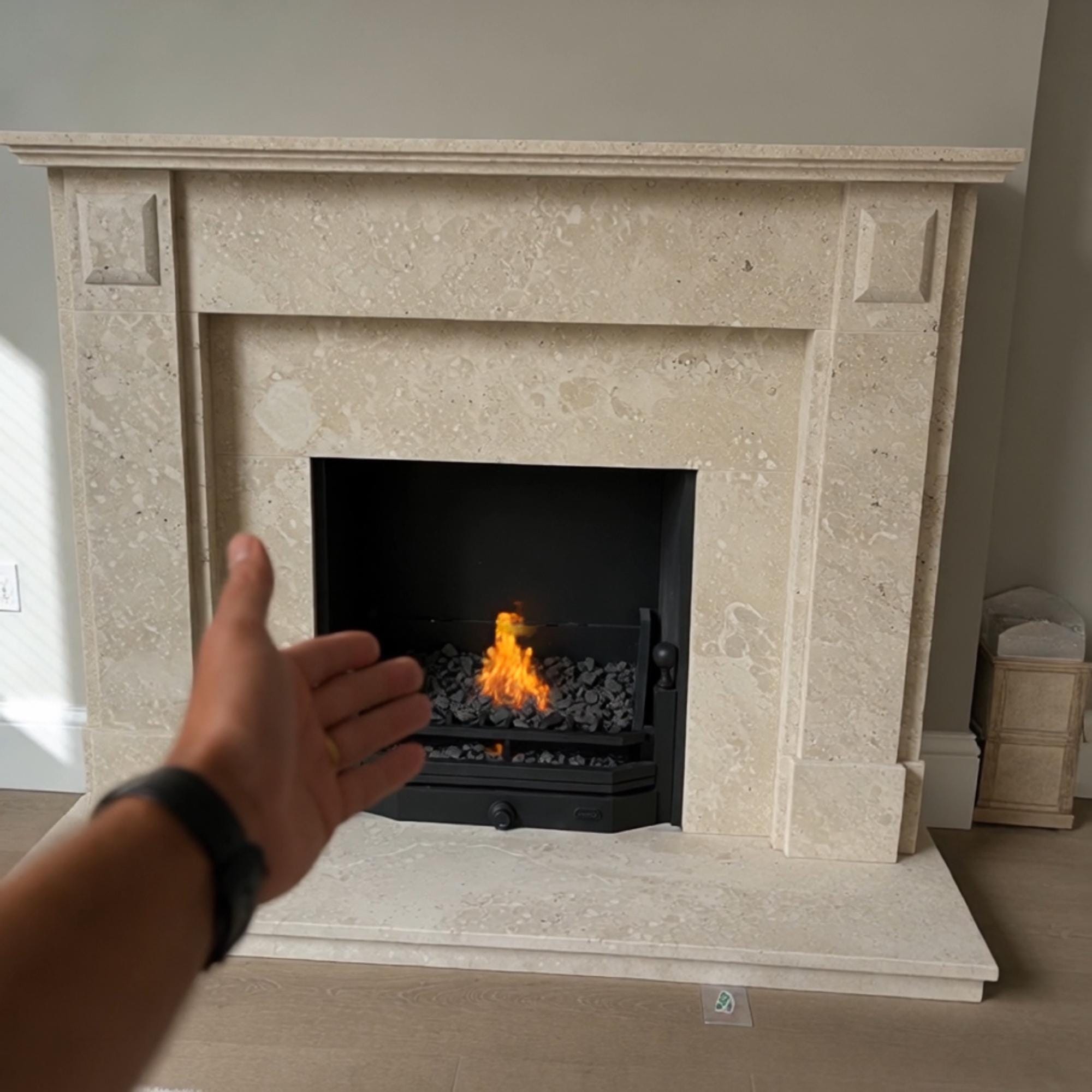Custom handcrafted marble fireplace surround in warm beige tones with traditional detailing