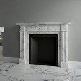 Classic white marble fireplace mantel with fluted columns and circular central motif, handcrafted from natural stone