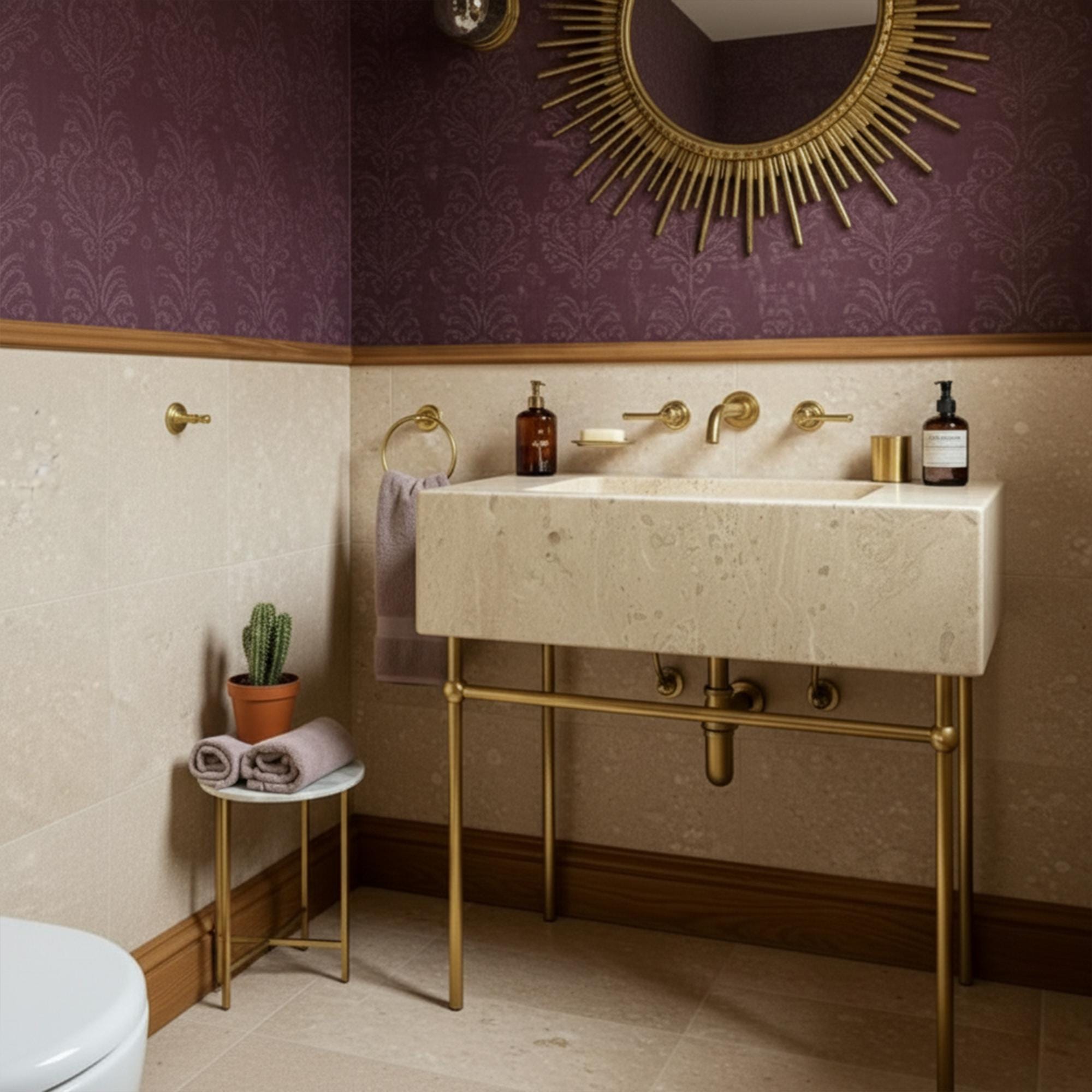 Elegant travertine sink floating above a sleek brass structure in a soft-toned powder room.