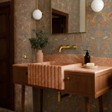 Fluted pink marble apron sink with matching backsplash on mid-century wood vanity and brass wall-mounted faucet