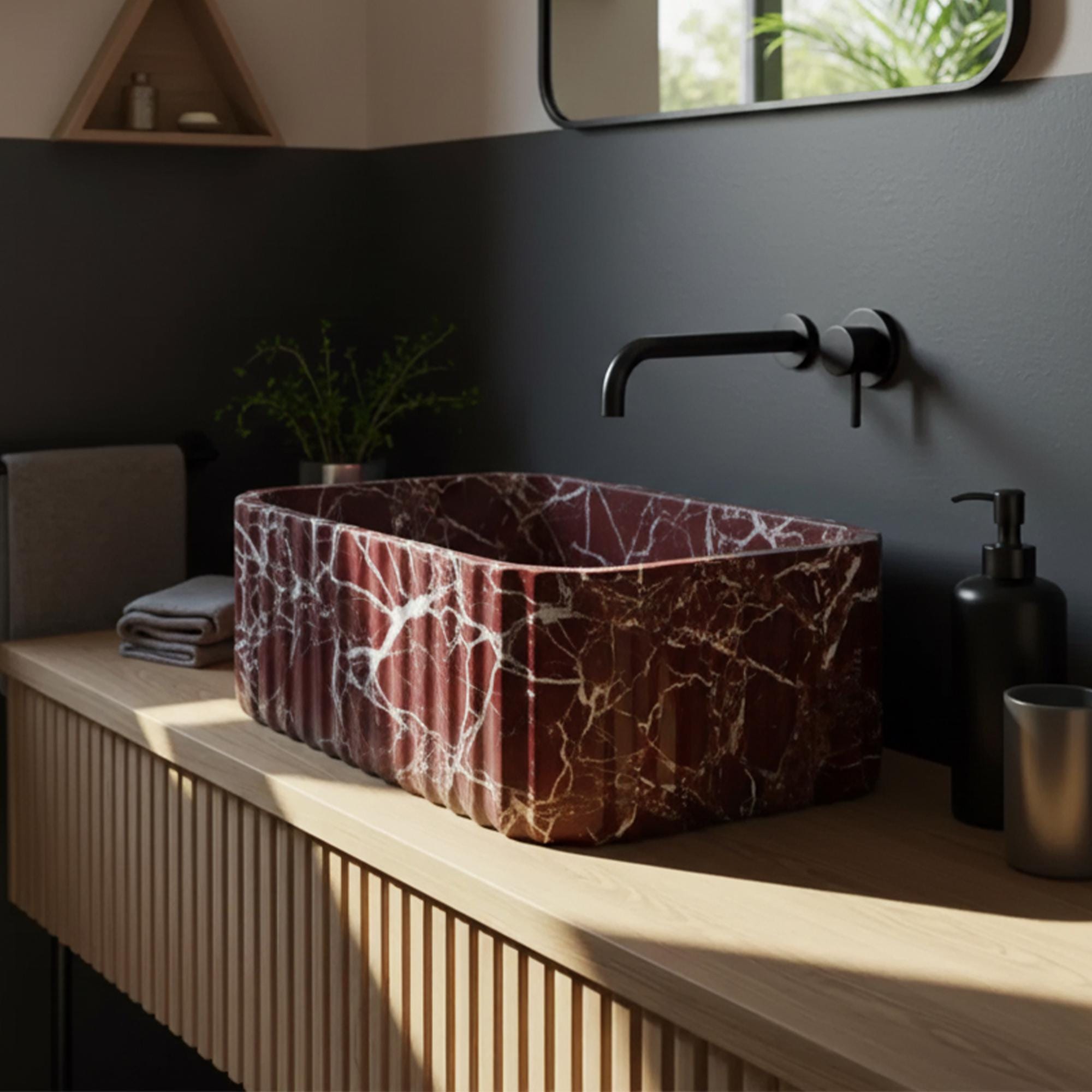 Rosso Levanto cherry marble fluted vessel sink on light wood vanity with matte black wall-mounted faucet