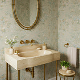 Hand-carved travertine marble sink with organic curved edges, wall-mounted on an elegant brass stand